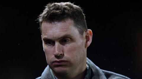 Exeter City manager Matt Taylor blows out cheeks and looks down
