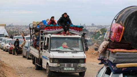 Palestinians wait to cross through a checkpoint run by US and Egyptian security contractors after Israeli forces withdrew from the Netzarim Corridor near Gaza City, 9 February 2025