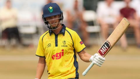 Jack Hope-Bell raises his bat to acknowledge the crowd's applause
