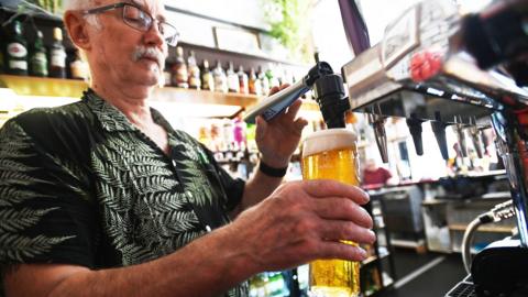 A pub landlord pulls a pint at a pub in London, Britain, 30 August 2022. 