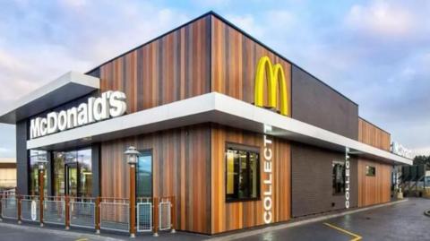 A McDonald's branded drive-thru restaurant with car lanes and a seating area.