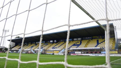 General view of Torquay United's stadium, Plainmoor, from behind a goal net.
