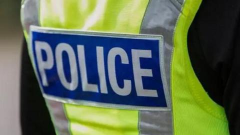 A cropped image showing a police office's hi-vis stab vest.