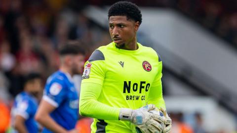Myles Roberts holds the ball as he looks to throw it out to a Walsall team-mate during a game