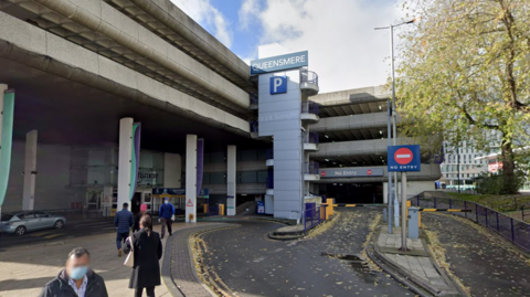 A screenshot from Google street view showing the entrance to a multi-storey car park on a sunny day.