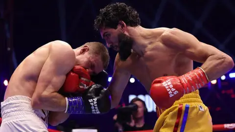 Hamzah Sheeraz throws a punch at Simon Zachenhuber