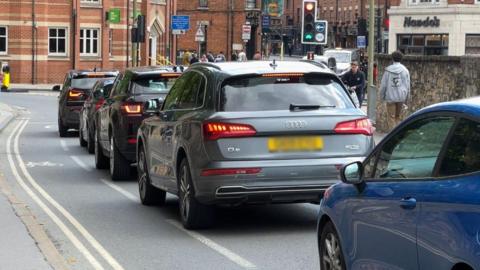 Cars queue at traffic lights on Hythe Bridge Street in Oxford. 