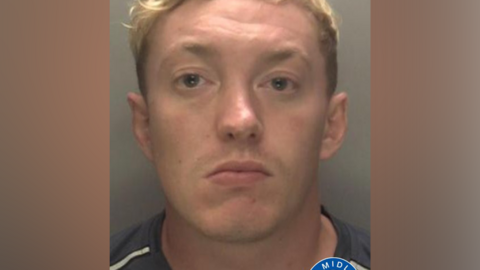 Callum Russell pictured in a mug shot. He short blonde hair and is clean shaven.