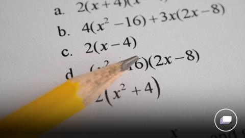 A photograph of a pencil pointing at algebra sums that have been typed.