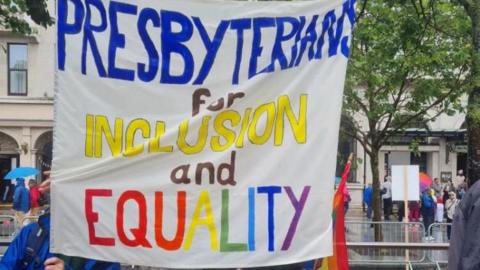 A hand painted sign that says "PRESBYTERIANS FOR INCLUSION AND EQUALITY" 