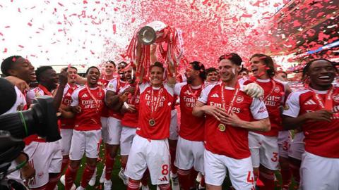 Arsenal captain Martin Odegaard lifts the Premier League trophy. 
