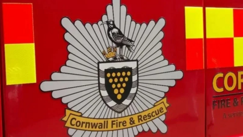 A Cornwall Fire and Rescue crest on the red door of a fire engine.