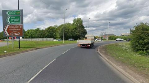 A picture of a roundabout shows several signs on the left indicating the way to Rother Valley Country Park, Sheffield Central and Aston. A vehicle drives along the right lane.