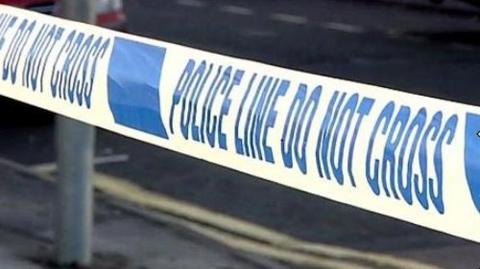 Generic close-up shot of a police cordon with blue writing on a white background