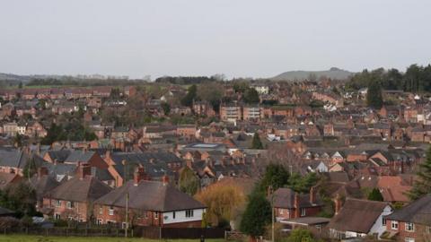 An overhead view of Ashbourne, showing a lot of brick buildings with an overcast sky.
