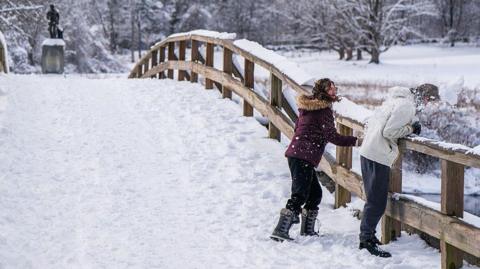 People throw snowballs on a snow-covered bridge in Massachusetts on 19 January