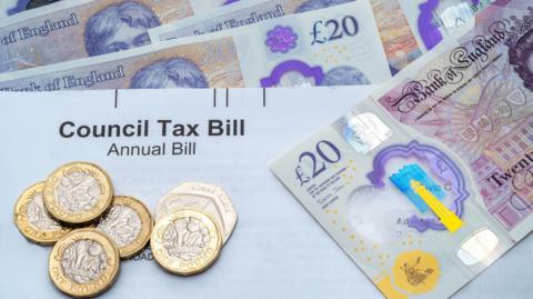 Council tax bill with coins and notes covering it up