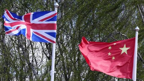 Union jack and China flags flying from flagposts