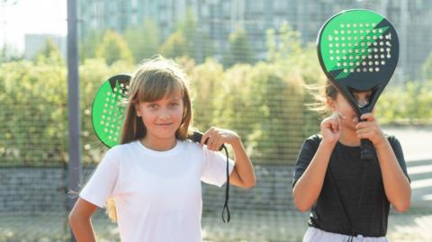children holding padel bats