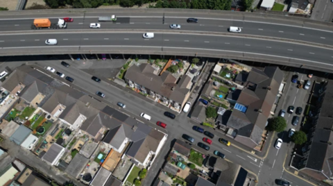 an overhead shot of the m4 motorway and the houses underneath
