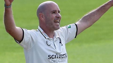 Chris Rushworth, with both arms aloft after taking a wicket in Championship cricket for Warwickshire
