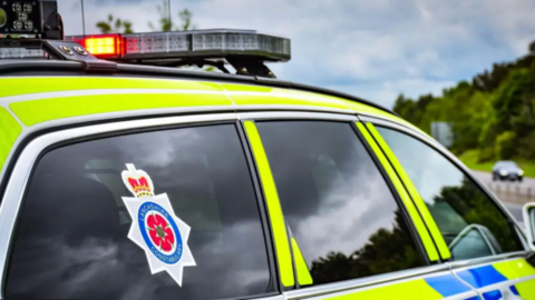 Library image of a Lancashire Constabulary police car, marked in fluorescent yellow and blue checks.
