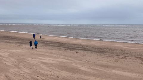 General view of Exmouth beach with people walking 