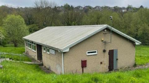 The building which hosts Rotherham Blackburn Club - a small space constructed from bricks with a corrugated plastic roof.