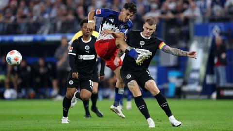 Nicolas Capaldo of Hamburger SV has a shot blocked by Eric Smith of St Pauli 