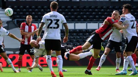 Lincoln City's Ben House (second right) flicks a Ivan Varfolomeev corner kick into the net against Derby County