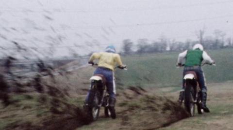 Two people riding motorcycles.