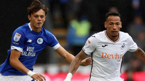 Perry Ng (left) of Cardiff City challenges Ronald of Swansea City