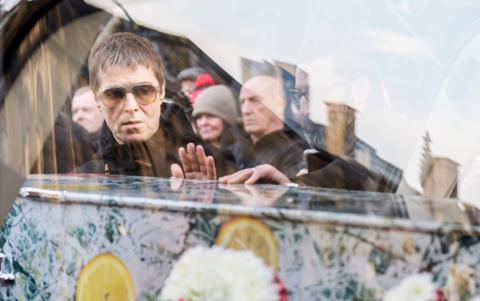 Liam Gallagher looks at the coffin as it is placed in the hearse following the funeral service of former Stone Roses and Primal Scream bass player Gary Mounfield, who was known as Mani, at Manchester Cathedral