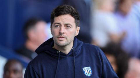 Ryan Mason wearing a West Brom navy hoodie at The Hawthorns during the Blackburn match