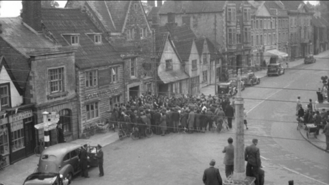 A black and white photo showing a crowd of people around a building in Chipping Sodbury