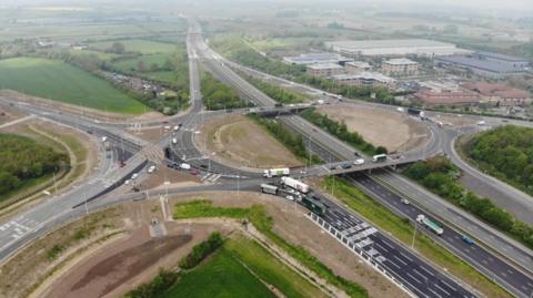 The M4 with multiple lanes of traffic and buildings and fields either side