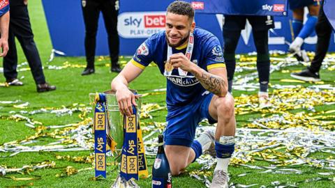 Marcus Browne poses with the League Two play-off final winners' trophy and his winner's medal