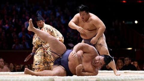 Tobizaru throws Shonannoumi during day one of The Grand Sumo Tournament at Royal Albert Hall 