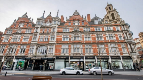 A large five-storey, ornate Victorian premises with several turrets, and shops at ground level