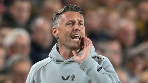 Middlesbrough manager Rob Edwards cups his hand to his mouth as he shouts from the touchline