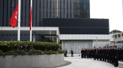 Officials attend a ceremony at Central Government Offices of Hong Kong to commemorate victims killed in the deadly fire at the Wang Fuk Court housing complex in Tai Po.