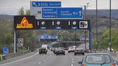 A motorway in Newport with blue signs indicating that drivers should be in the left hand lane for Newport and Cwmbran, and the right two lanes for Cardiff.