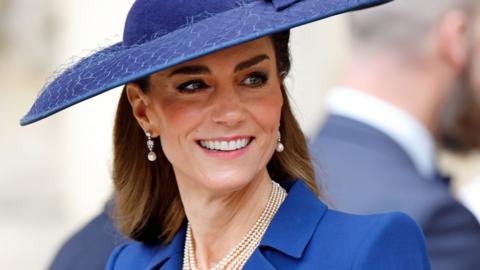 Catherine, Princess of Wales, wearing a blue hat, a blue jacket and pearl earrings and necklace, March 2026