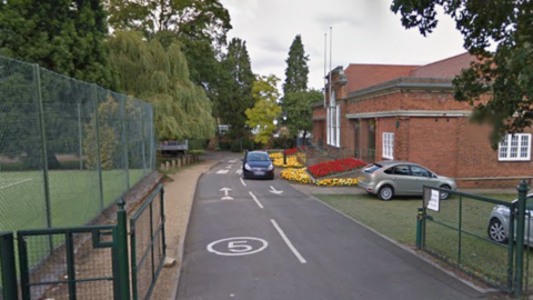 A Google streetview image of the exterior of Swanspool pavilion and a tennis court.