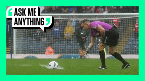 A referee rolls a ball that splashes in a puddle