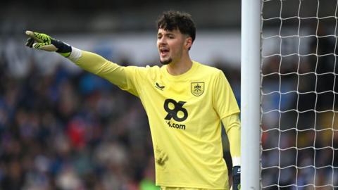 James Trafford delivers instructions to Burnley team-mates with his arm raised