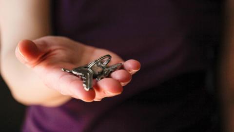 Outstretched hand holding a set of silver keys