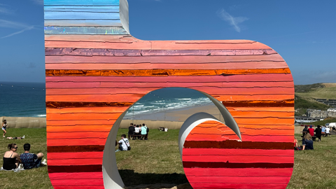 A picture of a sign at Boardmasters. It is a orange and red sign.
