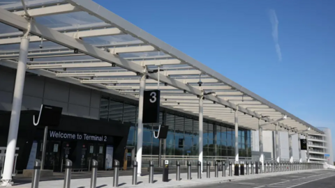 The white exterior and drop-off zone of Manchester Airport's Terminal 2.