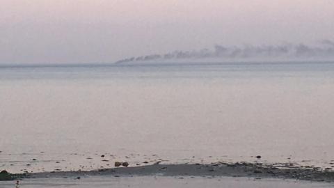 Smoke on the horizon from an out-of-view vessel, seen from the County Down coast